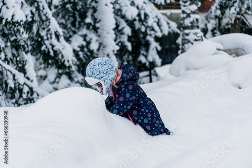 Little girl playing in a deep snow