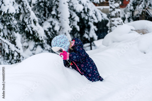 Little girl playing in a deep snow