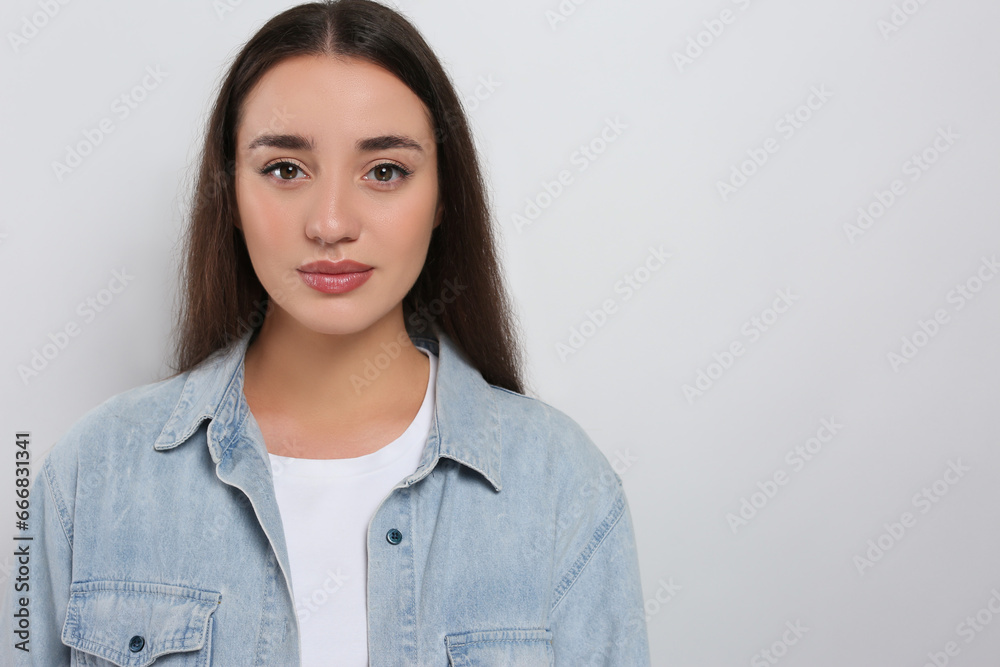 Portrait of beautiful young woman in jeans jacket on white background. Space for text Portrait of beautiful young woman in jeans jacket on white background. Space for text