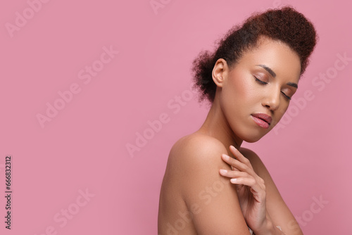 Portrait of beautiful young woman with glamorous makeup on pink background. Space for text