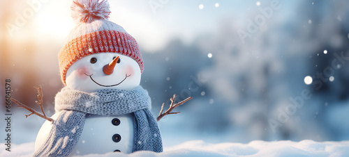 snowman closeup - cute, funny, laughing - wearing wool hat and scarf - on snowy snowscape - with bokeh lights - illuminated by the sun - winter holiday Christmas background banner With copy space