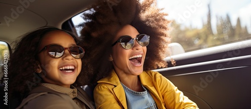 African American daughter and mother enjoying road trip in car
