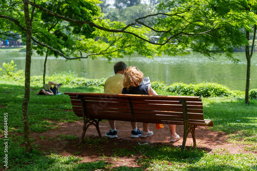 Casal de media idade curtindo um domingo no parque e relaxando em baixo da sombra da arvore