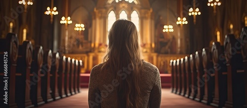 Female in Catholic place of worship engaged in prayer photo