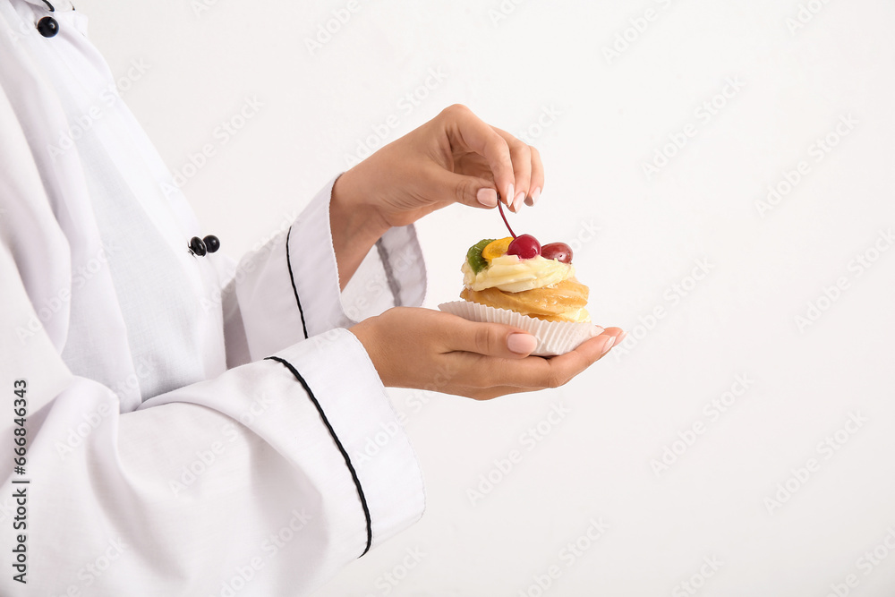 Female confectioner with tasty cake on white background Female confectioner with tasty cake on white background