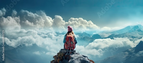 A happy girl in a turquoise helmet and windbreaker sits atop a mountain the traveler achieved their climb © AkuAku