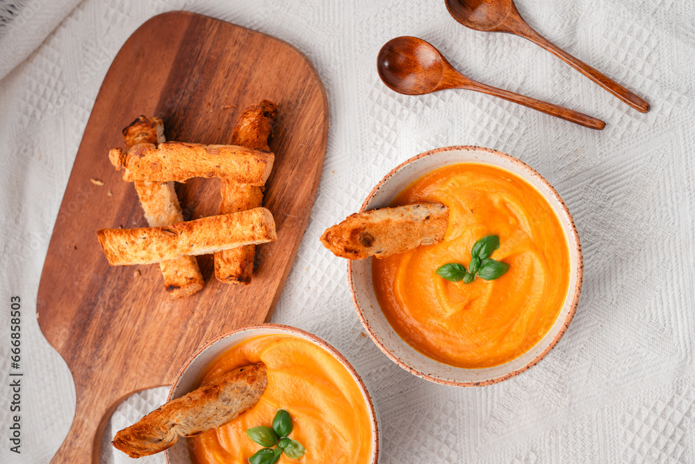 Pumpkin soup with toast on a wooden cutting board Pumpkin soup with toast on a wooden cutting board