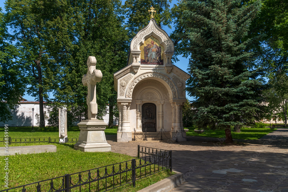 View of the monument-chapel of D.M. Pozharsky with a memorial cross in the architectural and museum complex of the Spaso-Evfimiev Monastery on a sunny summer day, Suzdal, Vladimir region, Russia