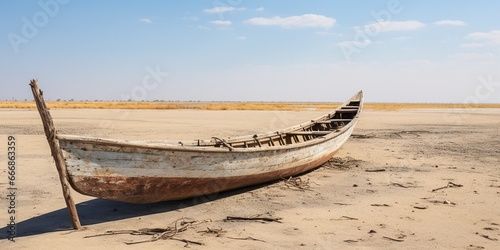 A traditional Marsh Arab canoe known as a Mashoof abandoned on the dry earth of the southern marshes of Iraq during a harsh summer drought caused by climate change and political instab : Generative AI photo