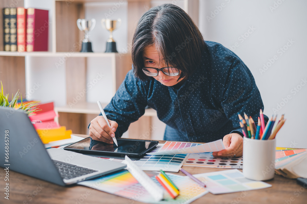 Graphic designer architects who work with laptops and color comparison tables for design work.. Graphic designer architects who work with laptops and color comparison tables for design work..