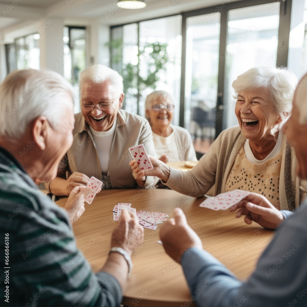 Group of seniors playing cards and sharing laughter in a retirement nursing home - obrazy, fototapety, plakaty 