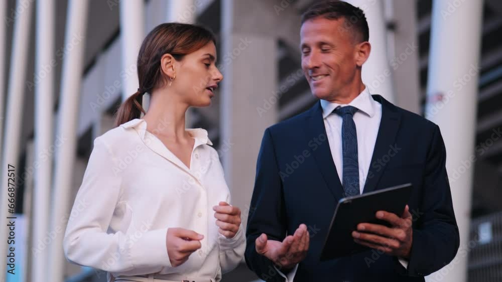 Happy professionals discuss on a tablet at sunset low-angle shot Happy professionals discuss on a tablet at sunset low-angle shot