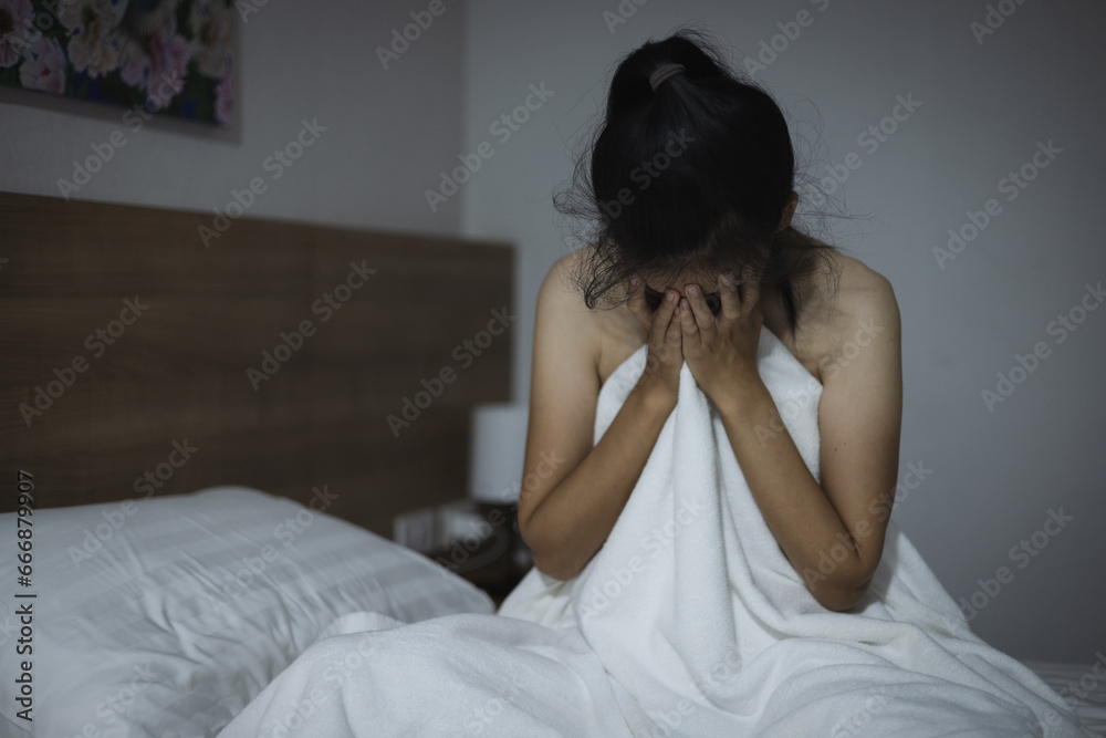 Woman covering face with hands while lying on bed at home. The concept of sexual harassment against women and rape. human trafficking. International Day for the Elimination of Violence against Women. Woman covering face with hands while lying on bed at home. The concept of sexual harassment against women and rape. human trafficking. International Day for the Elimination of Violence against Women.