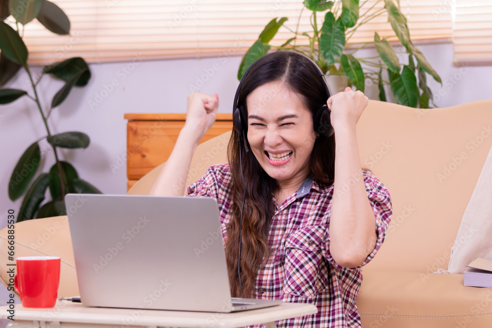 Asian woman sitting on floor happy excited with new job or online order from social media market remote working small business owner using technology laptop, modern freelancer female shop owner Asian woman sitting on floor happy excited with new job or online order from social media market remote working small business owner using technology laptop, modern freelancer female shop owner