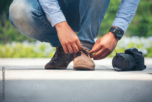 Man kneels down rope tie shoes industry boots for worker. Close up shot of man hands tied shoestring for his brown construction boots. Close-up man hands tie up shoes for footwear concept.