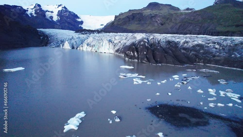 Aerial: A Glaciers serpentine path with deep crevasses and jagged ice formations, evidence of the impact climate change has on the constant movement and transformation of this natural wonder. photo