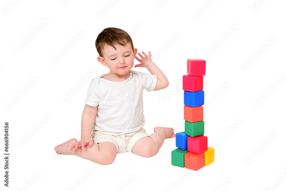 Happy baby play educational toys on studio, isolated on white background. Portrait of a smiling child playing while sitting on the floor. Kid about two years old (one year nine months) Happy baby play educational toys on studio, isolated on white background. Portrait of a smiling child playing while sitting on the floor. Kid about two years old (one year nine months)