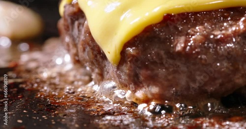 Macro shot of frying cutlets with melted cheese on top. Cinematic advertisement burger cooking. Homemade burger with cheese on grill pan. Flavorful, pan-fried pork cutlets. Fat high calorie food