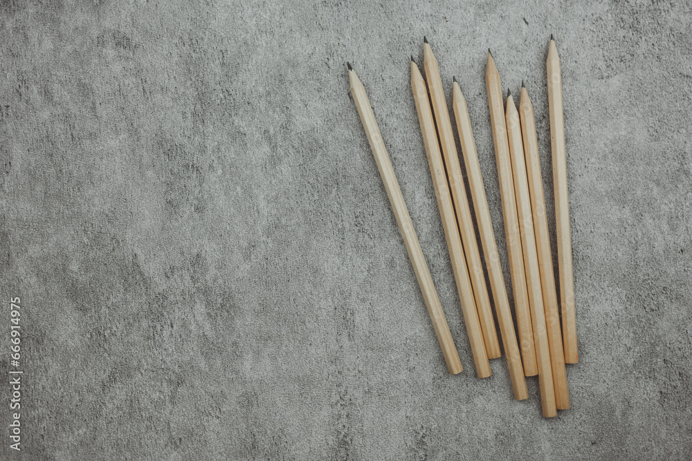 Many sharp pencils on a gray background. Top view. Space for text Many sharp pencils on a gray background. Top view. Space for text