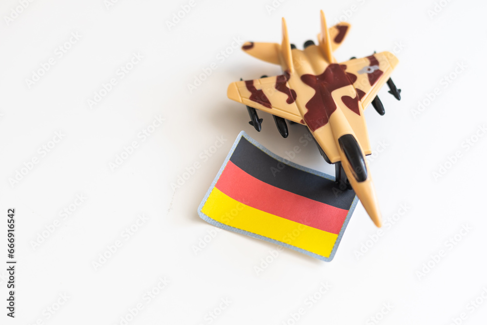 War, military threat, military power concept. Germany. Plane toy near German flag on grey background top view space for text War, military threat, military power concept. Germany. Plane toy near German flag on grey background top view space for text