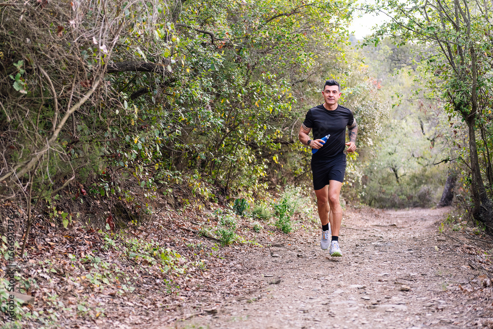 man practicing trail running in the forest, concept of sport in nature and healthy lifestyle, copy space for text man practicing trail running in the forest, concept of sport in nature and healthy lifestyle, copy space for text