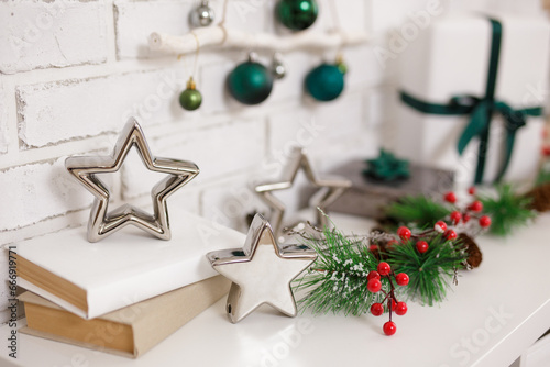Christmas branch of pine tree and stars on shelf