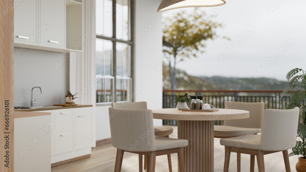 Fototapeta premium A modern Scandinavian kitchen with a dining table and a beautiful view through a balcony.