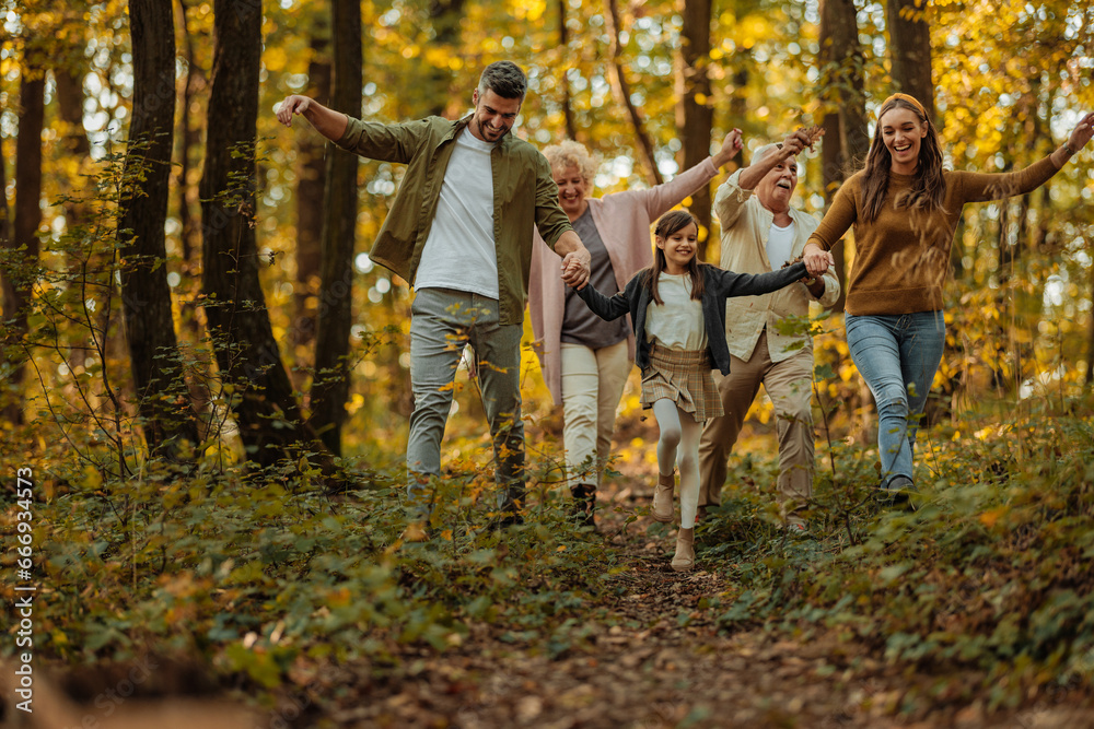 Whole family happily strolling in the woods - obrazy, fototapety, plakaty 