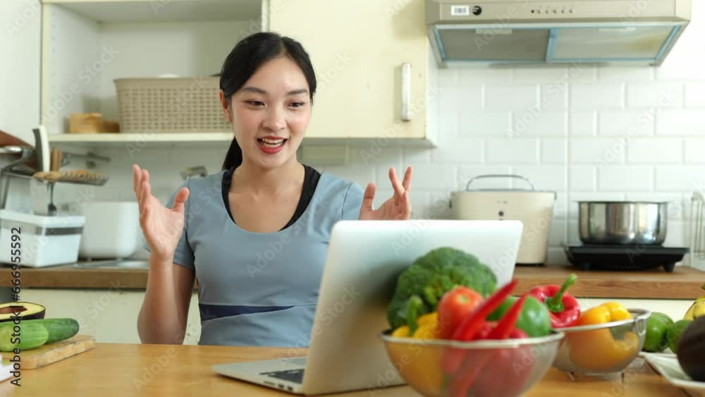Lifestyle in the kitchen A Young Asian woman talks live online via laptop about healthy eating and taking care of her body, skin, exercising at home. Lifestyle in the kitchen A Young Asian woman talks live online via laptop about healthy eating and taking care of her body, skin, exercising at home.