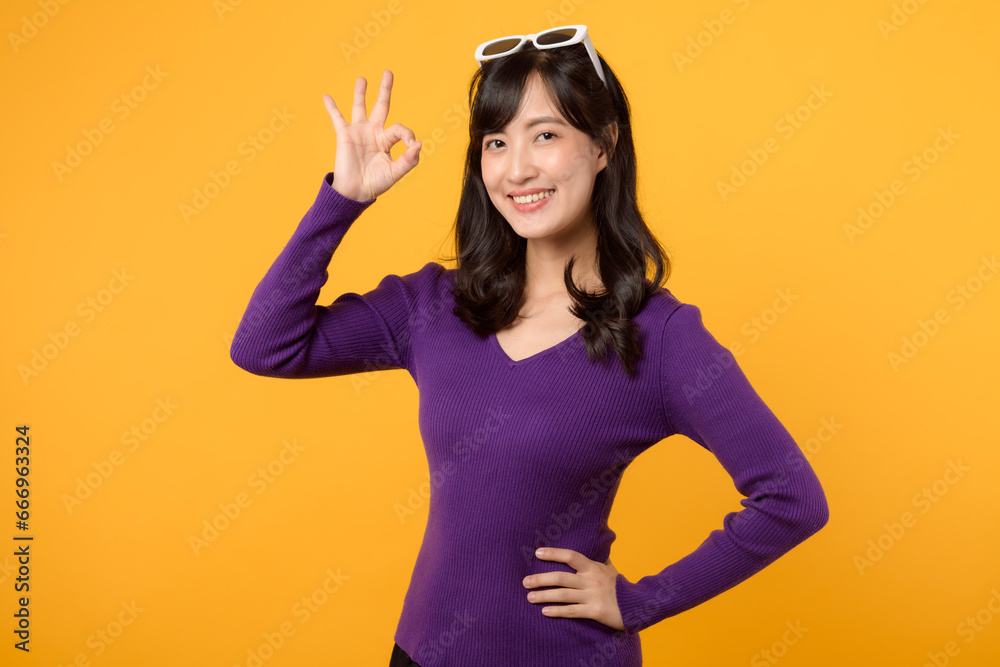 Confident person in purple shirt and sunglasses showing okay hand sign against a yellow background, radiating positivity with cheerful gestures and a friendly smile. Confident person in purple shirt and sunglasses showing okay hand sign against a yellow background, radiating positivity with cheerful gestures and a friendly smile.