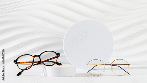 Glasses sale banner. Optic store sale-out offer. Trendy glasses in plastic and metallic frame on a podium on white background. Copy space. For banner, web line. Optic store discount, eyewear promotion