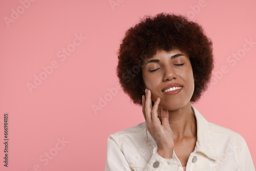 Portrait of happy young woman on pink background. Space for text