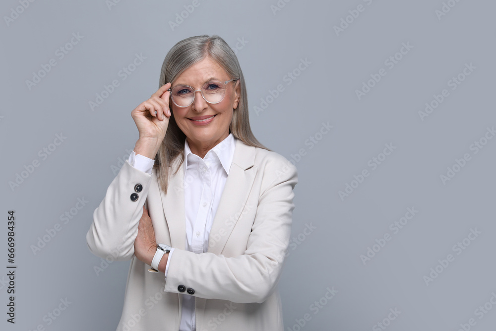 Portrait of beautiful senior woman in glasses on grey background. Space for text Portrait of beautiful senior woman in glasses on grey background. Space for text