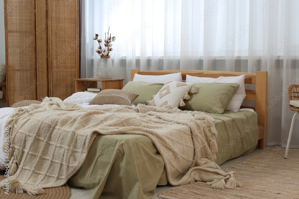 Large comfortable bed with soft pillows and blanket in room. Home textile Large comfortable bed with soft pillows and blanket in room. Home textile