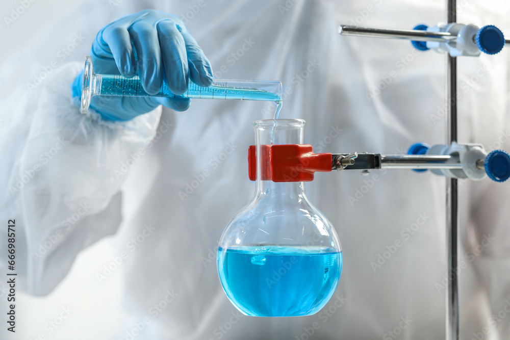 Scientist working with flask and test tube in laboratory, closeup Scientist working with flask and test tube in laboratory, closeup