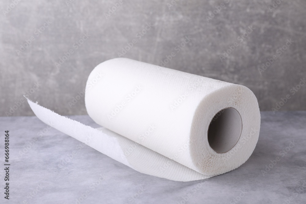 Fototapeta premium One roll of paper towels on grey table, closeup