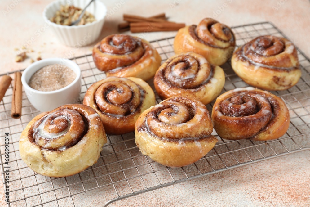 Tasty cinnamon rolls and sticks on beige textured table