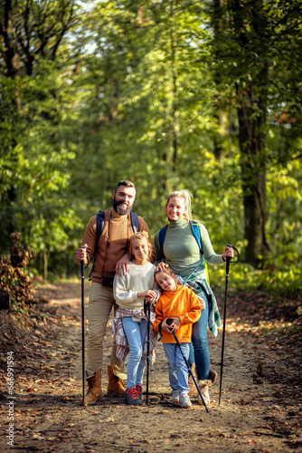 Portrait of smiling family of four exploring nature on a scenic forest hike. © Zoran Zeremski