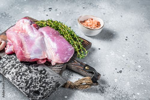 Poultry fresh meat, Raw Turkey thigh fillet on wooden cutting board. Gray background. Top view. Space for text
