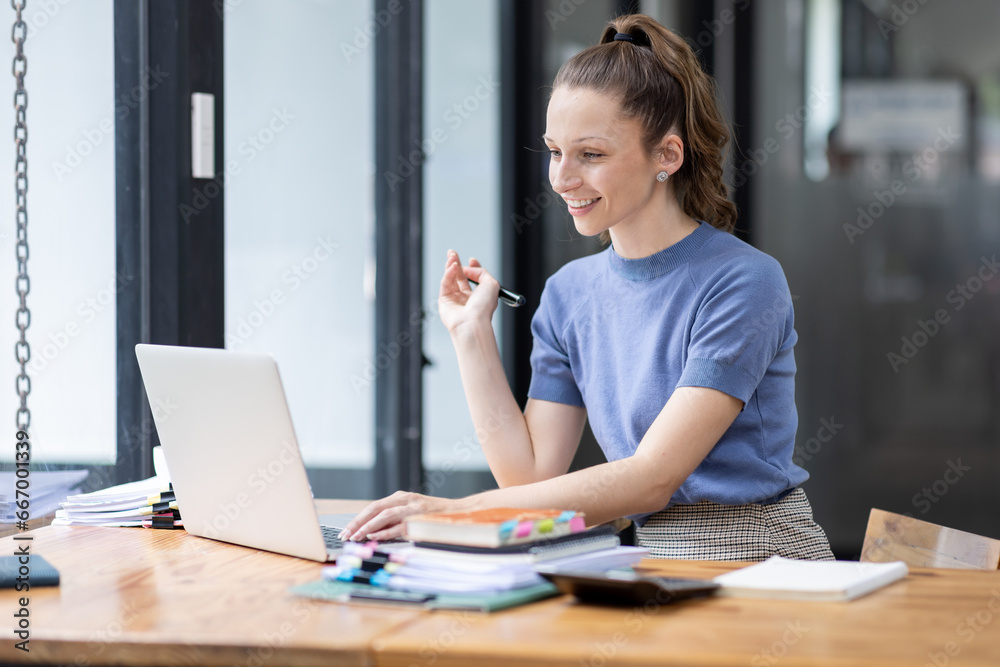 Image of young beautiful joyful Canada woman smiling while working with laptop in office Image of young beautiful joyful Canada woman smiling while working with laptop in office