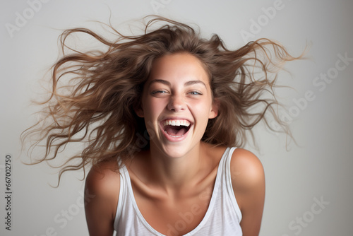 Photo of very happy young woman over gray background