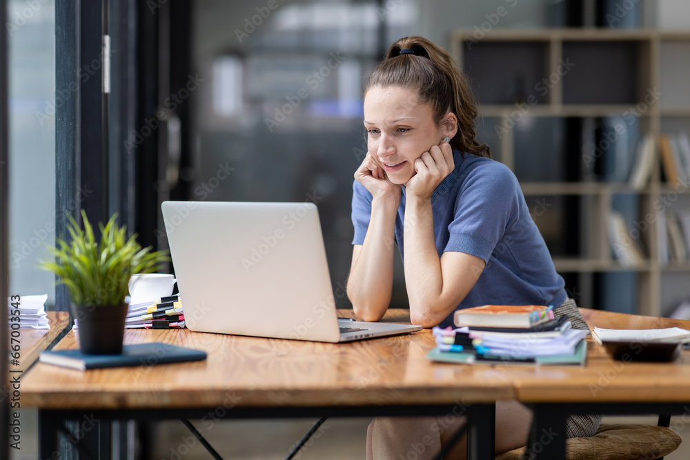 Fototapeta premium Portrait of tired young business Canada woman work with documents tax laptop computer in office. Sad, unhappy, Worried, Depression, or employee life stress concept