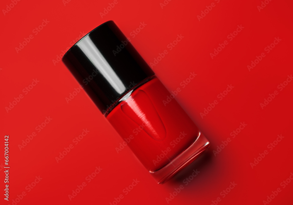 Red nail polish bottle over bright red background, top view. Gel nailpolish, shellac UV, bottle with brush, varnish, manicure concept, Beauty salon. Glass bottle close up. Nail care product. Red nail polish bottle over bright red background, top view. Gel nailpolish, shellac UV, bottle with brush, varnish, manicure concept, Beauty salon. Glass bottle close up. Nail care product.