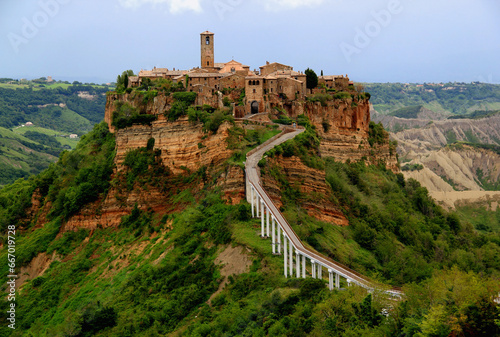 Panoramic view of the valley and town of Civita di Bagnoregio with stone houses on a high cliff in the province of Viterbo, Lazio region, Italy photo
