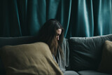 Shot of a unrecognizable woman sitting on a sofa and feeling anxious