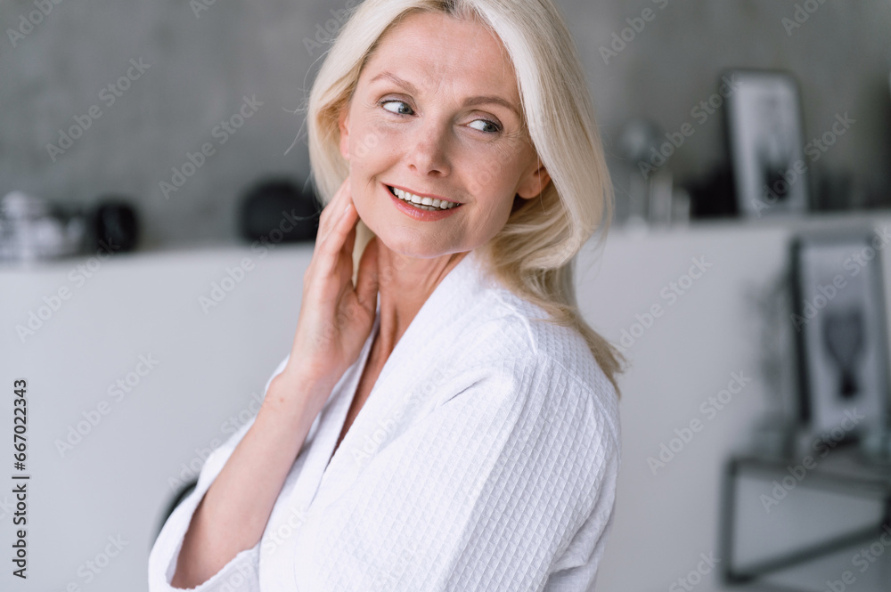 Mid aged woman look aside, touching her perfect smooth skin Mid aged woman look aside, touching her perfect smooth skin
