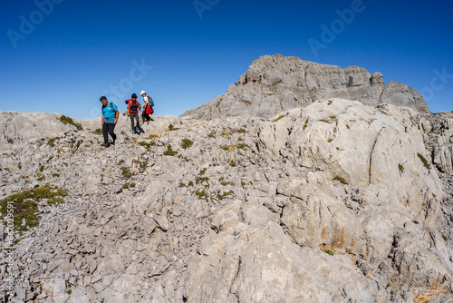 hiker advancing through the limestone relief of the Arres de Anie, Anie peak, Larra limestone plateau, Navarrese-French Pyrenees, Navarra, Spain