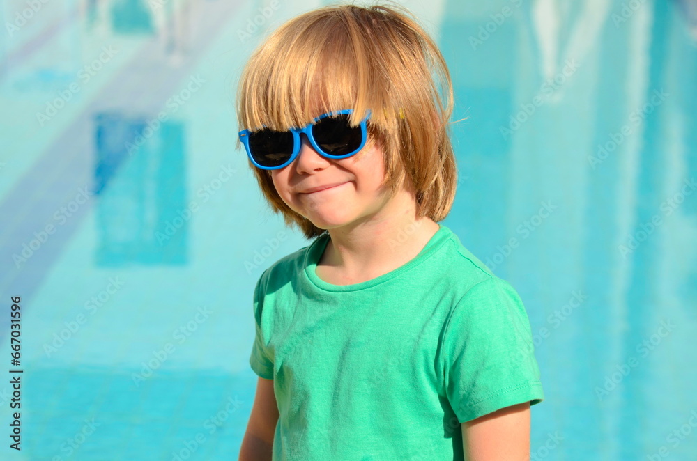 Little boy in a sun lounger at a resort near the pool. Children on vacation, summer days Little boy in a sun lounger at a resort near the pool. Children on vacation, summer days