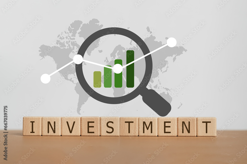 INVESTMENT text on wooden cube blocks with world map background and ...