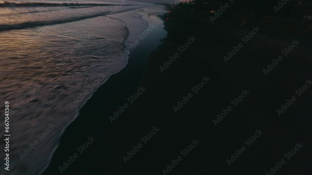 Aerial view man motorcyclist riding empty night sunset beach sea tropical landscape. FPV sport drone low cinematic shot evening dusk coast flying over endless tide calm foam wave ocean water surface